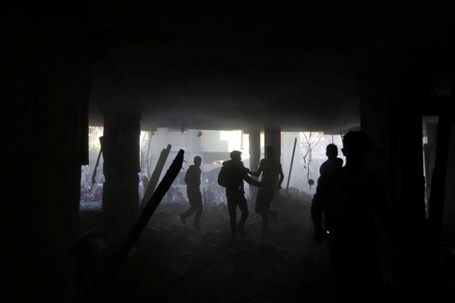 فلسطينيون داخل مبنى تعرض لضربة جوية إسرائيلية في قطاع غزة